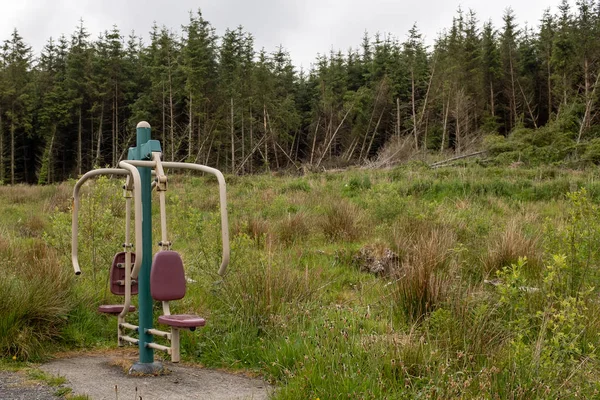Um equipamento de exercício aleatório num campo perto de uma floresta — Fotografia de Stock