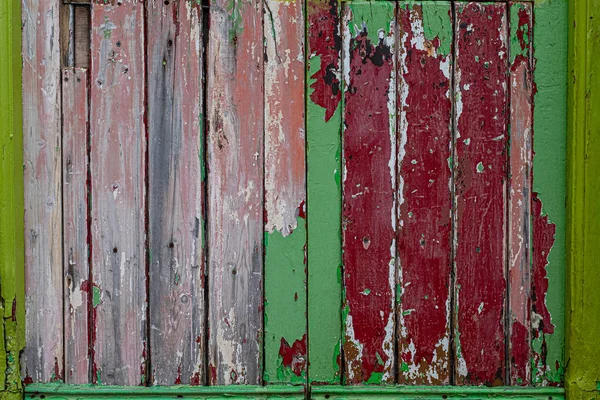 质朴的风化木板门，油漆剥落，留下不同颜色的层 — 图库照片