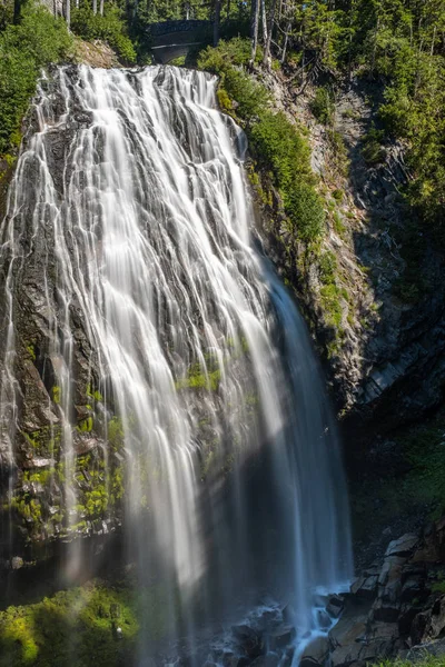 A large drop waterfall photographed on a long exposure to create blurred motion to the water, the Narada Waterfall, Mount Rainier National Park, Washington State, USA