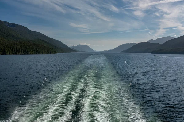 A vista da parte de trás de um ferry enquanto faz sua maneira através da passagem interna fora da costa ocidental áspera de Canadá, a luz que desvanece-se na distância — Fotografia de Stock