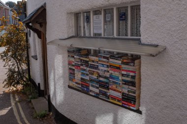 Lympstone, Devon, UK, Nisan, 8, 2019: Devon bir köyde bir pencere eşik Satılık kitap yığını, tüm para kaldırdı yerel cankurtaran fon gider