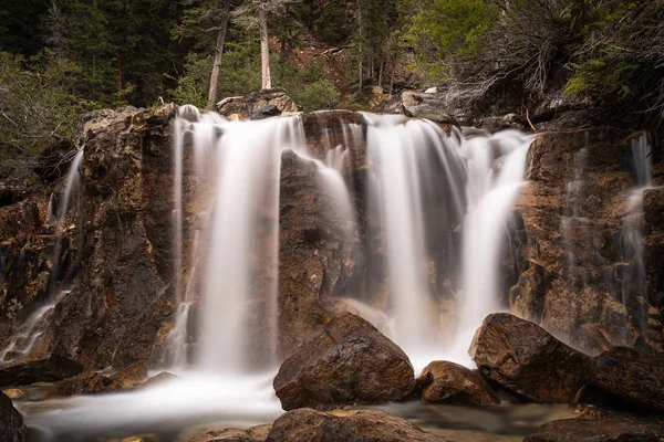 Un'ampia cascata con rocce in primo piano — Foto Stock