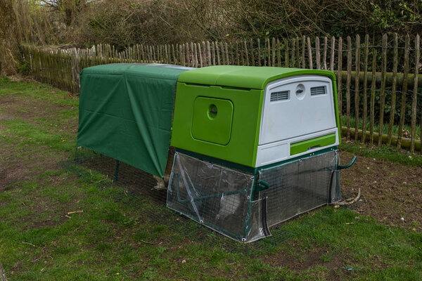 Зеленый современный ярко выглядящий куриный переворот или курятник с покрытой крышей
