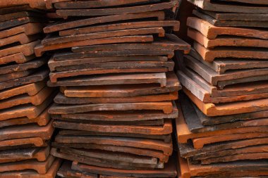 Karoların uzun kenarına bakarak, birbirlerinin üstüne yığılmış kırmızı kil çatı karoları bir yığını