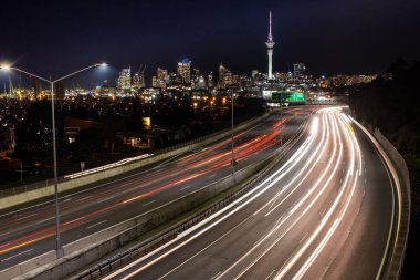 Şehir silüeti ile Auckland 'a giden gece araba ışık parkurları