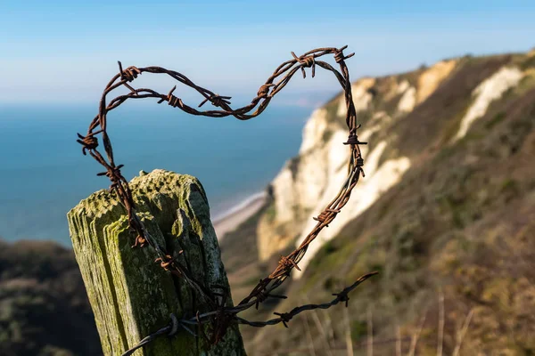 Fil barbelé en forme de coeur avec une toile de fond de falaises blanches dans le Devon — Photo