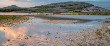 Küçük bir gölün kenarından alınan Burren Milli Parkı, Ilçe Clare, Irlanda olan manzara gibi çarpıcı ve Mars uzun bir pozlama
