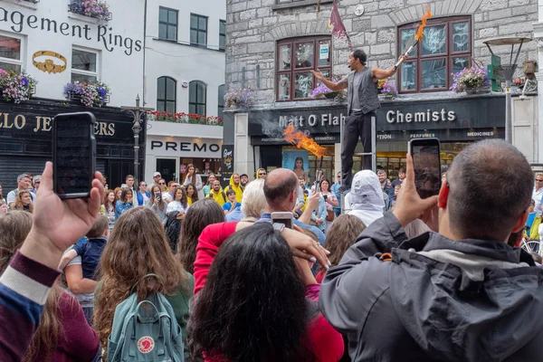 Ein Feuerschlucker Straßenunterhalter mit einer großen Menschenmenge, die in Galway zusieht, Irland wird von Menschen mit ihren Handys gefilmt — Stockfoto