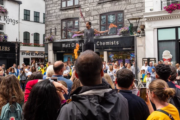 Ein Feuerschlucker Straßenunterhalter mit einer großen Menschenmenge in Galway, Irland — Stockfoto