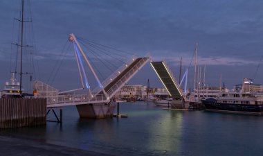 Auckland, Yeni Zelanda, 26 Kasım 2014; Wynard Quarter, Auckland'da açılan bir salıncak köprüsünün gün batımı manzarası.