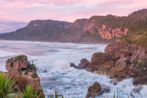 Yeni Zeland Batı Sahili'nde gün batımında engebeli kıyı şeridi bir görünüm 