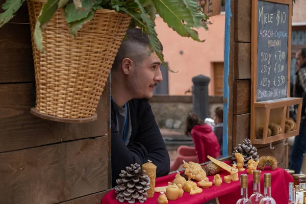 Man looking bored at a market stall at a craft market in Italy — Stock Photo, Image