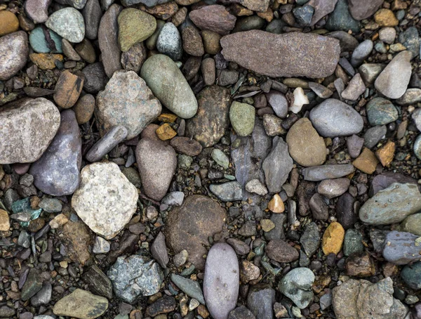 A textura de uma pedra rasa do rio. Imagem de fundo de seixo — Fotografia de Stock