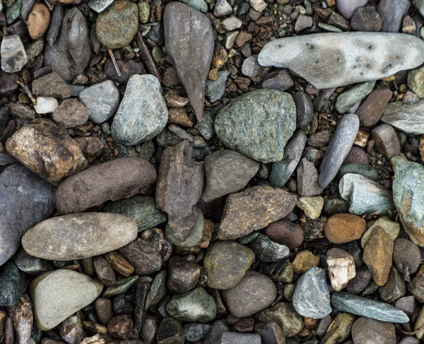 Die Textur eines flachen Flusssteins. Kieselstein Hintergrundbild — Stockfoto