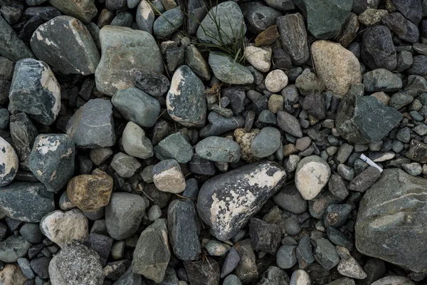 A textura de uma pedra rasa do rio. Imagem de fundo de seixo — Fotografia de Stock