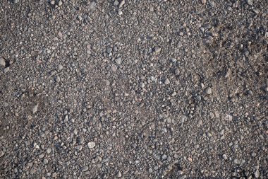 Yerdeki küçük çakıllarla kaplı yüzeyin arkaplan görüntüsü. Duvar kağıdı. Metin için substrat. Yerdeki ince çakıl taşlarının detaylı dokusu. Yürüyüş parkurunun yüzeyi. Üst görünüm.