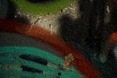 Eski beton duvarın dokusu boya ile kaplıdır. Çatlamış eski boya nın dokusu. Bir kask boyalı duvar bir arka plan görüntüsü. Beton duvardaki eski grafiti yakın mesafeden vurulmuş. Grafik kaynakları soyut dokulu arka plan.