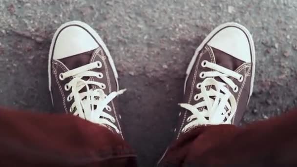 一个穿着深红色牛仔裤和黑色和白色运动鞋 带白色花边的男子用脚敲打着地面 一个人用脚敲打音乐节奏 — 图库视频影像