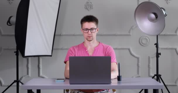 Guy Glasses Pink Shirt Sits Table Works Laptop Interior Photo — Stock Video