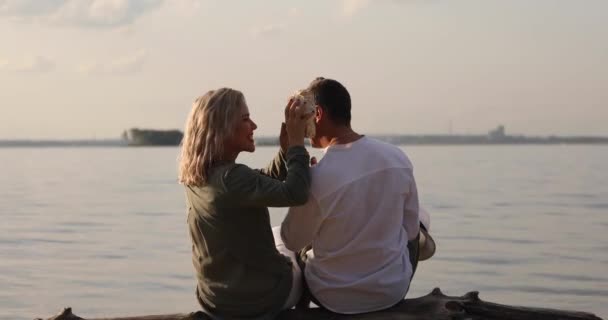 Mulher Homem Estão Sentados Tronco Junto Mar Pôr Sol — Vídeo de Stock