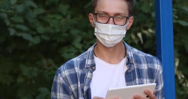 Homem Uma Máscara Antiviral Uma Camisa Com Tablet Suas Mãos — Vídeo de Stock