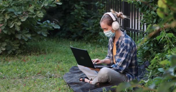 Mulher Máscara Antiviral Senta Uma Xadrez Parque Trabalha Laptop — Vídeo de Stock