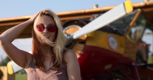 Mooie Vrouw Rood Bril Poseren Achtergrond Van Het Vliegtuig — Stockvideo