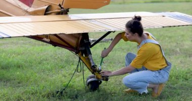 Tulumlu kadın uçağı tamir ediyor.