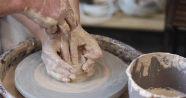 Bir çömlekçinin çarkında çamura bulanmış eller.