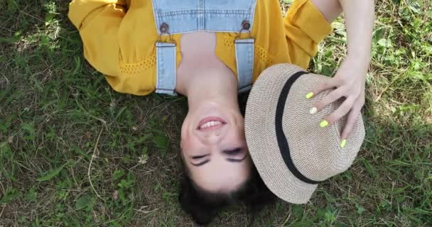 Дівчина Лежить Траві Закриває Обличчя Від Сонця Солом Яним Капелюхом — стокове відео