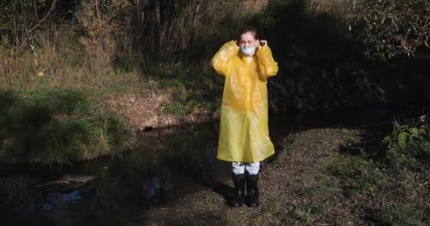 Sarı Yağmurluklu Bir Kadın Yüzünde Virüs Önleyici Bir Maske — Stok video