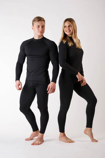 Guy e menina em roupa interior térmica em um fundo branco — Fotografia de Stock