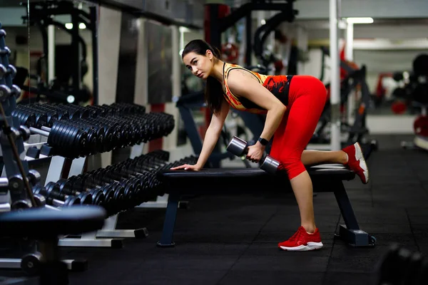 Meisje in de sportschool. Gaat naar binnen voor sport, op fitnessapparaten — Stockfoto