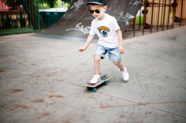 Paten parkında paten yapan bir çocuk. Gözlüklü bir çocuk paten kaymayı öğrenir..