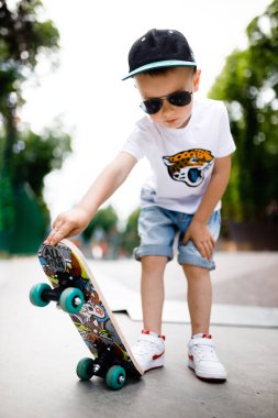 Paten parkında paten yapan bir çocuk. Gözlüklü bir çocuk paten kaymayı öğrenir..