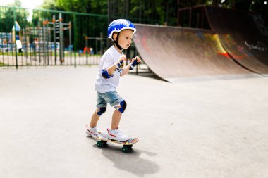 Paten parkında paten yapan bir çocuk. Çocuk tam koruma içinde paten kaymayı öğreniyor..