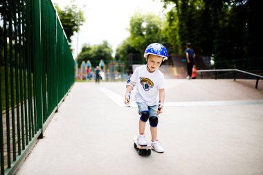 Paten parkında paten yapan bir çocuk. Çocuk tam koruma içinde paten kaymayı öğreniyor..