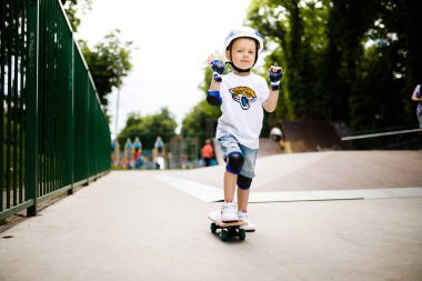 Paten parkında paten yapan bir çocuk. Çocuk tam koruma içinde paten kaymayı öğreniyor..