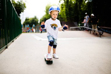 Paten parkında paten yapan bir çocuk. Çocuk tam koruma içinde paten kaymayı öğreniyor..