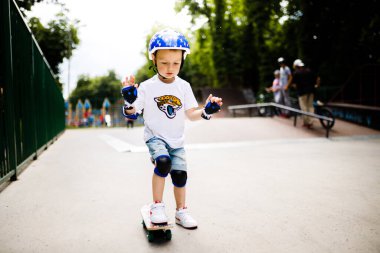 Paten parkında paten yapan bir çocuk. Çocuk tam koruma içinde paten kaymayı öğreniyor..