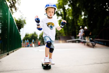 Paten parkında paten yapan bir çocuk. Çocuk tam koruma içinde paten kaymayı öğreniyor..
