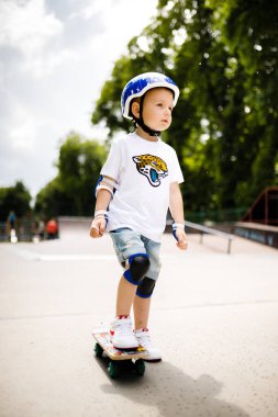 Paten parkında paten yapan bir çocuk. Çocuk tam koruma içinde paten kaymayı öğreniyor..