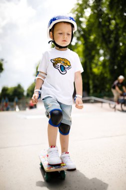 Paten parkında paten yapan bir çocuk. Çocuk tam koruma içinde paten kaymayı öğreniyor..