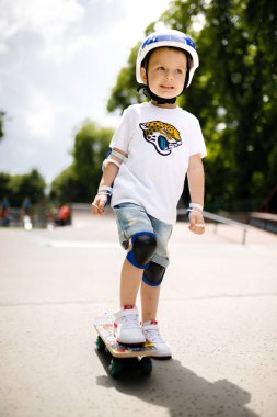 Paten parkında paten yapan bir çocuk. Çocuk tam koruma içinde paten kaymayı öğreniyor..