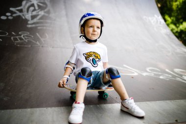 Paten parkında paten yapan bir çocuk. Çocuk tam koruma içinde paten kaymayı öğreniyor..