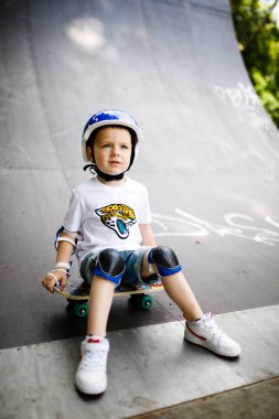 Paten parkında paten yapan bir çocuk. Çocuk tam koruma içinde paten kaymayı öğreniyor..