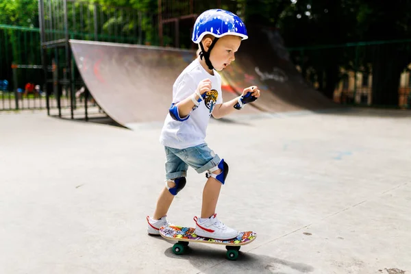 Paten parkında paten yapan bir çocuk. Çocuk tam koruma içinde paten kaymayı öğreniyor..