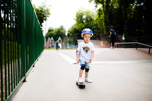 Paten parkında paten yapan bir çocuk. Çocuk tam koruma içinde paten kaymayı öğreniyor..