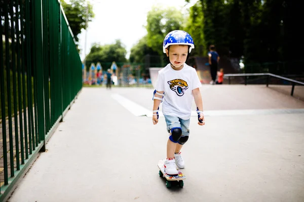 Paten parkında paten yapan bir çocuk. Çocuk tam koruma içinde paten kaymayı öğreniyor..