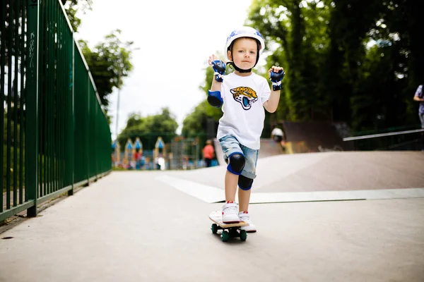 Paten parkında paten yapan bir çocuk. Çocuk tam koruma içinde paten kaymayı öğreniyor..